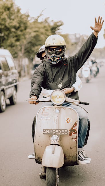 Two people cheerfully riding a vintage Vespa scooter in East Java, Indonesia.
